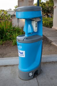Portable hand washing station on the sidewalk at a park
